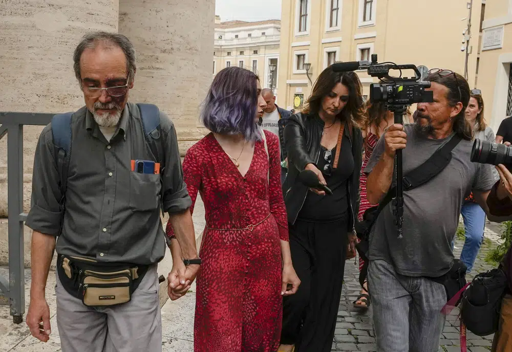 FILE - Ultima Generazione (Last Generation) activists Ester Goffi, second from left, and Guido Viero, left, arrive at The Vatican, Wednesday, May 24, 2023, where they are on trial for having staged a protest in August inside the Vatican Museums. A Vatican court on Monday, June 12, 2023, convicted the two environmental activists of aggravated damage and ordered them to pay more than 28,000 euros (US$30,000) in damages after they glued their hands to the base of an ancient statue in the Vatican Museums in a protest to draw attention to climate change. (AP Photo/Alessandra Tarantino, File)