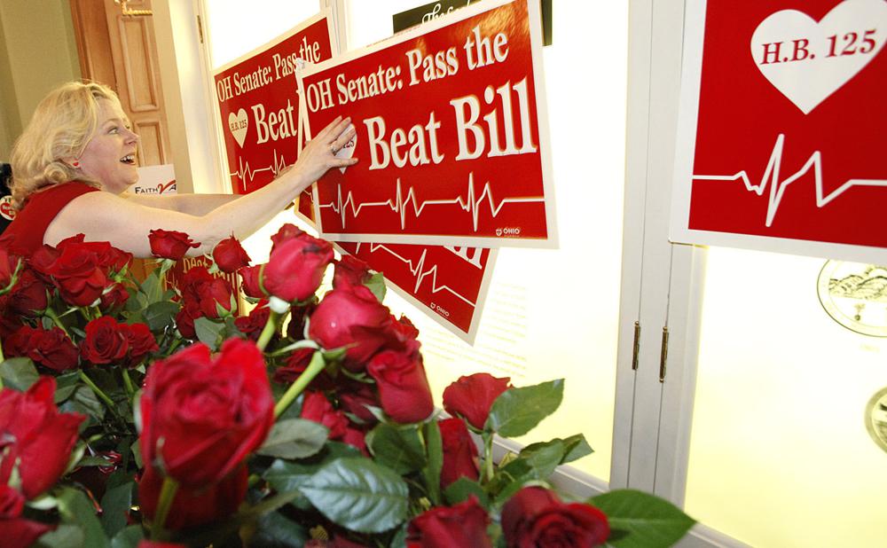 FILE - In this Feb. 14, 2012, file photo, Janet Folger Porter, president and founder of Faith 2 Action, posts signs during a news conference at the Ohio Statehouse in Columbus, Ohio. Bans pegged to the “fetal heartbeat” concept have been signed into law in 12 states, but all have either been struck down or temporarily blocked by the courts and none has taken effect. Porter urged supporters to “take heart” when faced with obstacles — and beseeched lawmakers to “have a heart” and vote “yes" despite their constitutional concerns. (Brooke LaValley/The Columbus Dispatch via AP, File)