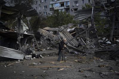 Un anciano pasa junto a un concesionario de autos destruido por un ataque ruso en Zaporiyia, Ucrania, el martes 11 de octubre de 2022. (AP Foto/Leo Correa)