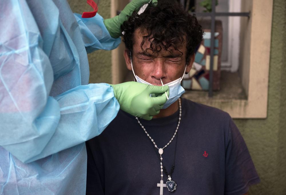 ARCHIVO - En esta fotografía de archivo del 4 de febrero de 2021, un trabajador de la salud realiza pruebas rápidas de COVID-19 en un refugio para personas sin hogar en Montevideo, Uruguay.  (AP Foto/Matilde Campodonico, Archivo)