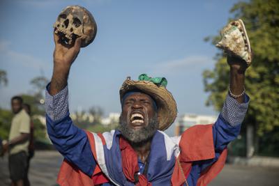 Un manifestante que sostiene una calavera y una concha de mar exige a gritos la renuncia del primer ministro haitiano Ariel Henry, el lunes 17 de octubre de 2022, en Puerto Príncipe, Haití. (AP Foto/Odelyn Joseph)