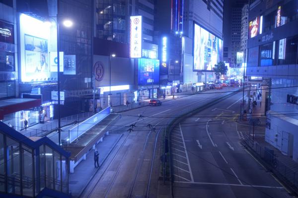 Una mujer se para en una calle vacía generalmente llena de compradores en Causeway Bay, un famoso distrito comercial en Hong Kong el jueves 10 de marzo de 2022. Las luces de neón de Hong Kong todavía están encendidas, pero COVID-19 ha apagado gran parte de la energía habitual de la ciudad. En cambio, ahora hay una sensación inusual de limbo. Las concurridas calles comerciales y los distritos de oficinas están mucho más vacíos que nunca. (AP Foto/Vincent Yu)