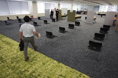 Un empleado del fabricante de bebidas Suntory camina para recibir la vacuna contra el COVID-19 desarrollada por Moderna en el edificio de la compañía, el lunes 21 de junio de 2021, en Tokio. (AP Foto/Eugene Hoshiko)