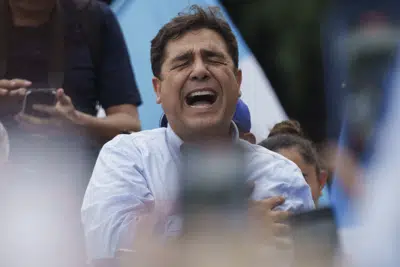 El candidato presidencial Carlos Pineda, del partido Prosperidad Ciudadana, entona el himno nacional tras salir de la Corte de Constitucionalidad en la Ciudad de Guatemala, el sábado 20 de mayo de 2023. (AP Foto/Moisés Castillo)