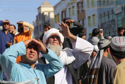 La gente mira un cadáver colgado por los talibanes de una grúa en la plaza principal de la ciudad de Herat, en el oeste de Afganistán, el sábado 29 de septiembre de 2021. (AP Foto)