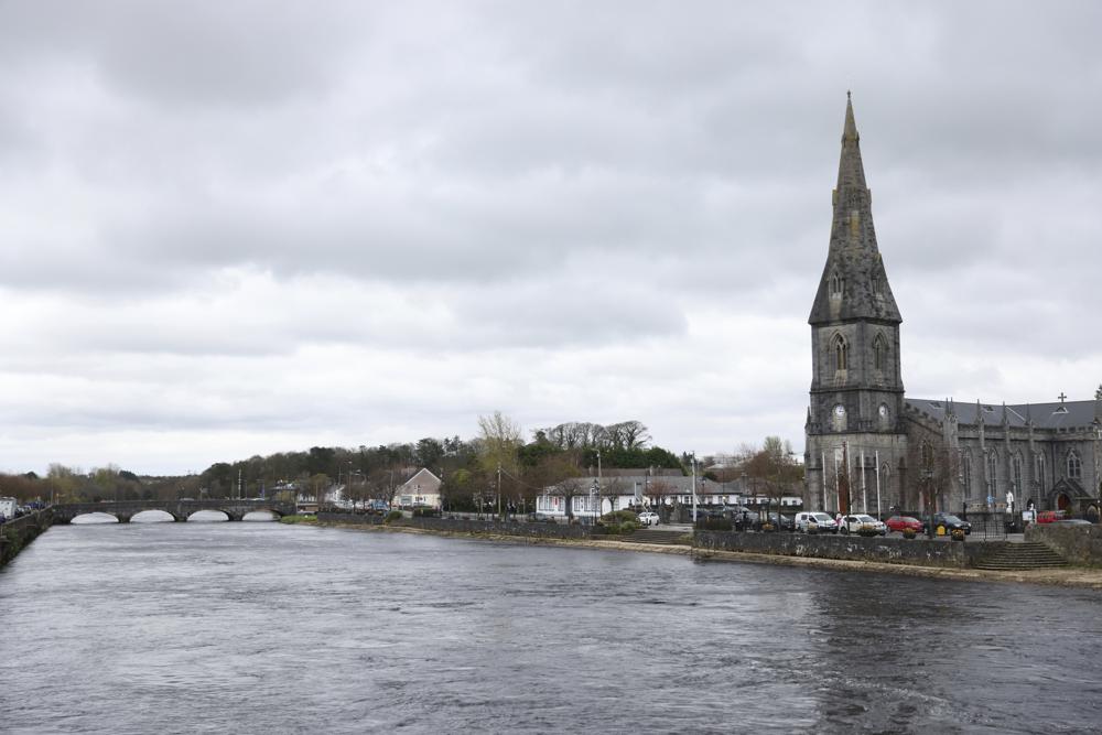 A general view of St Muredach's Cathedral by the river Moy, in Ballina Ireland, Tuesday, April 4, 2023. Excitement is building in Ballina, a small Irish town that was home to some of President Joe Biden's ancestors. Biden is scheduled to visit the town next week, part of a four-day trip to Ireland and neighboring Northern Ireland. (AP Photo/Peter Morrison)