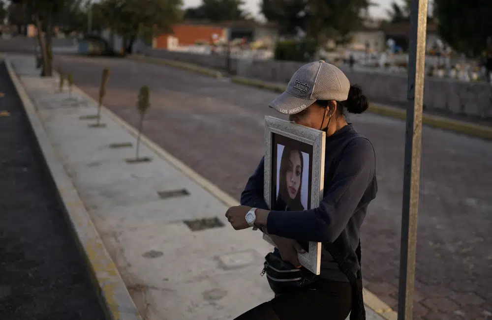 Un amiga de Mónica Citlalli Díaz carga su fotografía durante el funeral en un panteón en Ecatepec, Estado de México, México, el viernes 11 de noviembre de 2022. Díaz, una profesora de inglés de 30 años, al parecer fue la novena víctima durante una serie de feminicidios a lo largo de 11 días ocurridos en Ciudad de México y sus alrededores entre finales de octubre e inicios de noviembre. (Foto AP/Eduardo Verdugo)