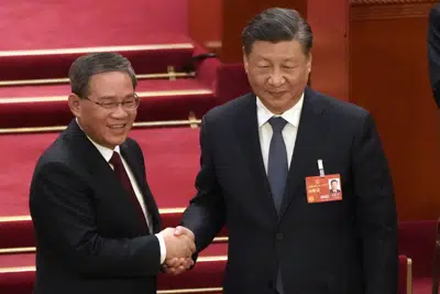 El recién elegido primer ministro Li Qiang, a la izquierda, estrecha la mano del presidente chino Xi Jinping durante una sesión de la Asamblea Popular Nacional (APN) de China en el Gran Palacio del Pueblo en Beijing, el sábado 11 de marzo de 2023. (AP Photo/Mark Schiefelbein)