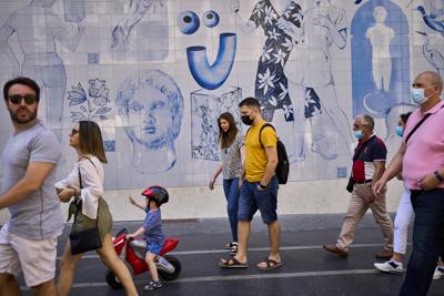 Personas caminan por una calle en Madrid el 26 de junio del 2021. La tasa de infecciones con coronavirus en España está subiendo, impulsada por brotes entre los jóvenes y los no vacunados, revelan datos del Ministerio de Salud. (AP Foto/Manu Fernandez)
