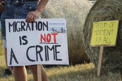 Una mujer sostiene un letrero durante una protesta contra el trato violento hacia los migrantes, presuntamente cometido por la policía croata, cerca del cruce fronterizo entre Croacia y Bosnia Herzegovina en Maljeva, Croacia, el 19 de junio de 2021. (AP Foto/Edo Zulic, Archivo)