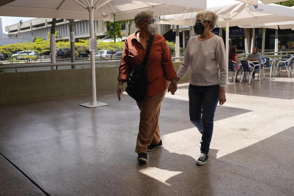 La pareja del mismo sexo Ana Margarita Rojas, izquierda, y Elena Hernáiz, caminan de la mano en un centro comercial en Caracas, Venezuela, el viernes 25 de febrero de 2022. “Estamos en un país donde ser ciudadano ya es una lucha cuesta arriba, ser reconocido como ciudadano minoritario es una lucha cuesta arriba”, dijo Rojas, de 59 años. (Foto AP/Ariana Cubillos)