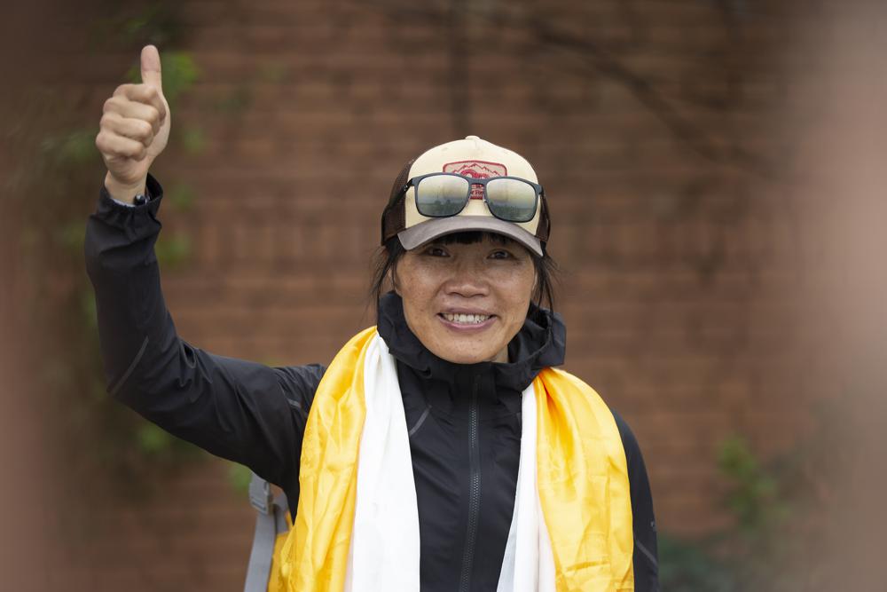 Tsang Yin-hung, 45, of Hong Kong who scaled Mount Everest from the base camp in 25 hours and 50 minutes, and became the fastest female climber gestures to media as she arrives in Kathmandu, Nepal, Sunday, May 30, 2021. The Hong Kong teacher and retired attorney from Chicago who became the oldest American to scale Mount Everest, on Sunday returned safely from the mountain where climbing teams have been struggling with bad weather and a coronavirus outbreak. (AP Photo/Bikram Rai)