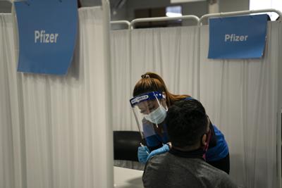 ARCHIVO - En esta fotografía del 21 de mayo de 2021, la enfermera Angeline Gabuten administra una vacuna contra el COVID-19 desarrollada por Pfizer a un paciente en un centro de vacunación de Santa Ana, California. (AP Foto/Jae C. Hong, Archivo)