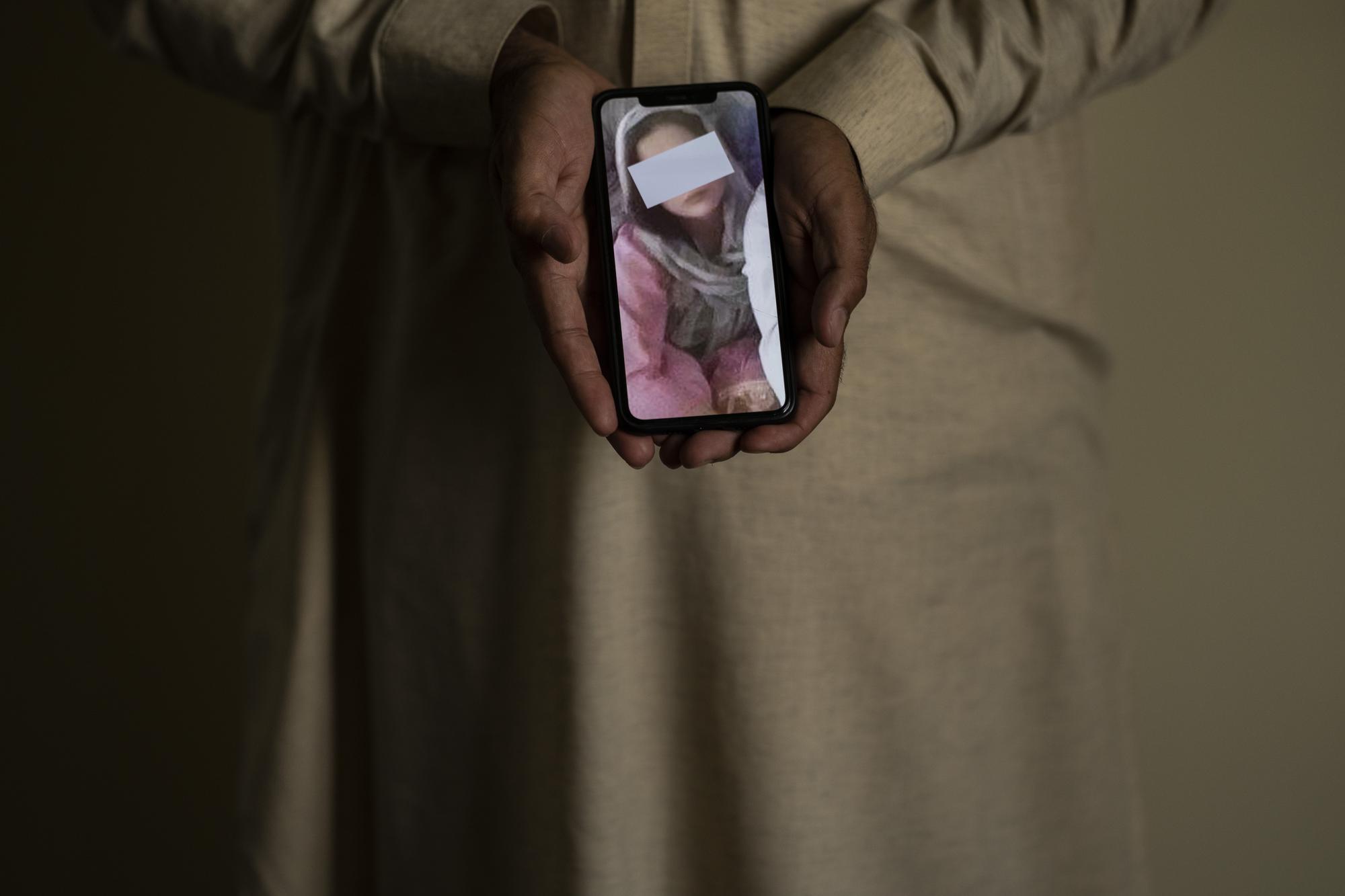 A picture, partially covering the identity of Popal's sister, is shown on a cell phone in Kabul, Afghanistan, Sunday, Sept. 26, 2021. The sisters went missing as she commuted between Kabul and Logar, and has not been heard from in weeks. The family fears it could be connected to warnings they received from relatives to stop the daughters from studies, Popal told the AP. (AP Photo/Bernat Armangue)