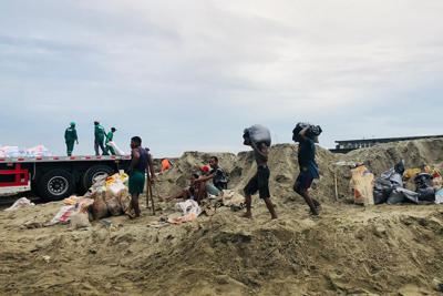 Gente volviendo a casa bajo el mal tiempo en Tamatave, Madagascar, el sábado 5 de febrero de 2022. (AP Foto)