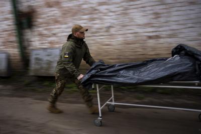 Darrell Loveless traslada cadáveres de los camiones refrigerados a la morgue en Bucha, en las afueras de Kiev, el lunes 25 de abril de 2022. (AP Foto/Emilio Morenatti)