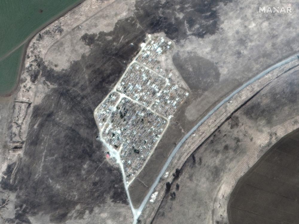 This satellite image provided by Maxar Technologies shows a cemetery before the expansion of graves near Vynohradne, approximately 12 kilometers east of Mariupol, Ukraine, on March 22, 2022. Since April 1 until mid-April, additional trenches have been excavated at the Vynohradne cemetery. (Satellite image ©2022 Maxar Technologies via AP)