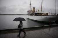 A pedestrian shields themselves with an umbrella while walking along the Halifax waterfront as rain falls ahead of Hurricane Fiona making landfall in Halifax, Friday, Sept. 23, 2022. (Darren Calabrese /The Canadian Press via AP)