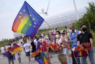 Aficionados al fútbol, con la bandera arcoiris que identifica al colectivo LGBTQI, en el exterior del Allianz Arena antes del partido del Grupo F de la Euro 2020 entre Alemania y Hungría, en Múnich, el 23 de junio de 2021. (AP Foto/Matthias Schrader)