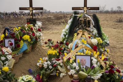 Las flores se colocan alrededor de las tumbas de los militares ucranianos Roman Rak y Mykola Mykytiuk en Starychi, al oeste de Ucrania, el miércoles 16 de marzo de 2022. Rak y Mykytiu murieron durante el ataque con misiles rusos del domingo contra una base de entrenamiento militar en Yavoriv. (AP Foto/Bernat Armangue)