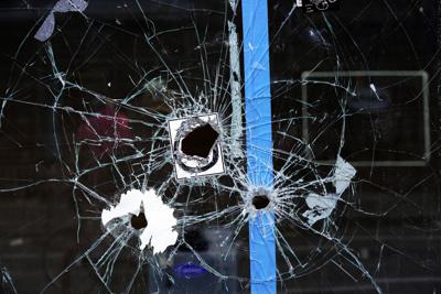 En esta fotografía se ve una ventana con agujeros de bala en el sitio de un tiroteo en South Street, Filadelfia, el domingo 5 de junio de 2022. (AP Foto/Michael Perez)