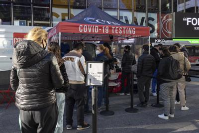 Varias personas hacen fila para que les hagan una prueba para detectar si no están contagiadas con el coronavirus en Times Square, Nueva York, el viernes 3 de diciembre de 2021. (AP Foto / Yuki Iwamura)