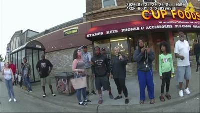 ARCHIVO- En esta fotografía de archivo del 25 de mayo de 2020 de una cámara portátil de policías, peatones, incluyendo a Darnella Frazier, tercera de derecha a izquierda filmando, mientras el ex policía de Minneapolis Derek Chauvin fue grabado presionando su rodilla sobre la nuca de George Floyd por varios minutos en Minneapolis. Frazier, quien grabó la muerte de Floyd, recibió una mención especial de los Premios Pulitzer el viernes 11 de junio de 2021 por grabar valientemente el video (Minneapolis Police Department via AP, File)