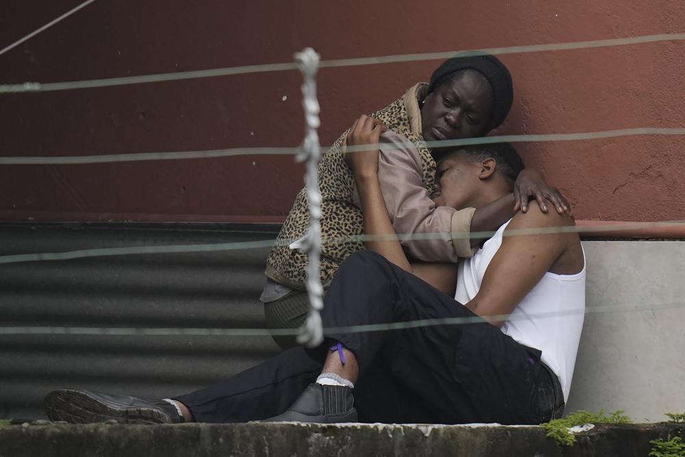 Una mujer abraza a un hombre después de aludes de tierra fatales en Petrópolis, Brasil, la madrugada del miércoles 16 de febrero de 2022. Lluvias extremadamente fuertes provocaron aludes e inundaciones en una región montañosa del estado de Río de Janeiro, matando a varias personas, informaron las autoridades. (AP Foto/Silvia Izquierdo)