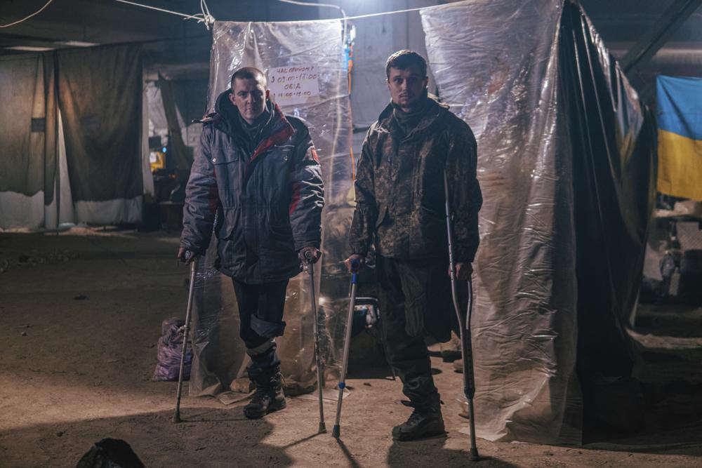 In this photo provided by Azov Special Forces Regiment of the Ukrainian National Guard Press Office, Azov Special Forces Regiment's servicemen, injured during fighting against Russian forces, pose for a photographer inside the Azovstal steel plant in Mariupol, Ukraine, Tuesday, May 10, 2022. (Dmytro 'Orest' Kozatskyi/Azov Special Forces Regiment of the Ukrainian National Guard Press Office via AP)