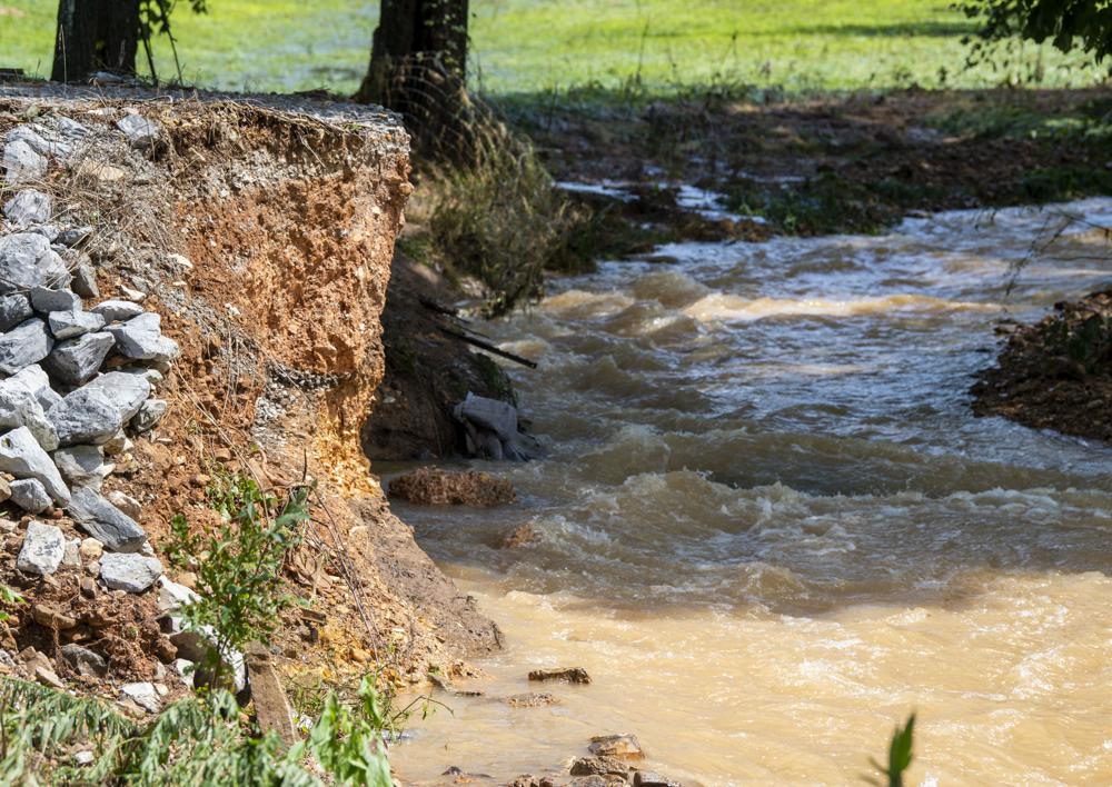 A driveway is washed away by flooding along Little Blue Creek Road following heavy rainfall Saturday, Aug. 21, 2021, in McEwen, Tenn. Heavy flooding in several Middle Tennessee counties on Saturday prompted water rescues, road closures, and communications disruptions, with several people reported missing. Flash flood warnings were in effect for Dickson, Houston and Montgomery and Stewart counties on Saturday evening. (Josie Norris/The Tennessean via AP)