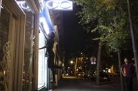 Hadj Benhalima from the the collective "On the Spot" jumps to turn off lights during a night of action where they will extinguish the lights on dozens of storefronts in Paris, Friday, July 29, 2022. The collective had been acting against wasteful businesses in Paris long before Russia started cutting energy supplies to Europe in a battle of wills over Moscow's invasion of Ukraine. As such, the campaigners were precursors of the energy economy drive becoming all the rage in France, Germany and elsewhere. (AP Photo/Lewis Joly)