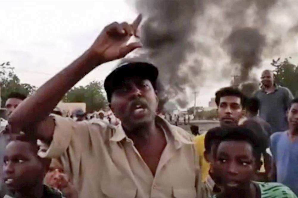 In this frame taken from video people gather during a protest in Khartoum, Sudan, Monday, Oct. 25, 2021. Military forces arrested Sudan's acting prime minister and senior government officials Monday, disrupted internet access and blocked bridges in the capital Khartoum, the country's information ministry said, describing the actions as a coup. In response, thousands flooded the streets of Khartoum and its twin city of Omdurman to protest the apparent military takeover. Footage shared online appeared to show protesters blocking streets and setting fire to tires as security forces used tear gas to disperse them. (New Sudan NNS via AP)