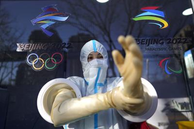 Un trabajador se apresta a aplicar una prueba de COVID-19 en los Juegos Olímpicos de Invierno en Beijing, martes 1 de febrero de 2022. (AP Foto/David J. Phillip)