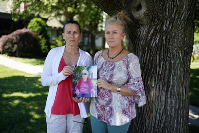 Angela Ermold, a la derecha, y su hermana, Denise Gracely, posan con una foto de su madre, Marian Rauenzahn, en Fleetwood, Pensilvania, el jueves 17 de junio de 2021. Ambas hermanas lamentan el largo aislamiento por la pandemia de su madre como de otros ancianos en los asilos. (AP Foto/Matt Slocum)