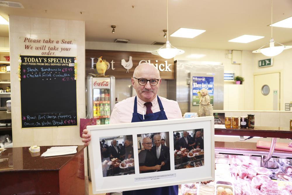 El carnicero Anthony Heffernan sostiene un conjunto de tres fotografías del presidente Joe Biden con él en su tienda el martes 4 de abril de 2023 en Heffernan Fine Foods en Ballina, Irlanda.  Las fotos fueron tomadas cuando Biden visitó en 2016, como vicepresidente.  La emoción está aumentando en Ballina, una pequeña ciudad irlandesa que fue el hogar de algunos de los antepasados ​​​​del presidente Joe Biden.  Biden tiene previsto visitar la ciudad la próxima semana, como parte de un viaje de cuatro días a Irlanda y la vecina Irlanda del Norte.  (Foto AP/Peter Morrison)