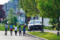 FILE - Children walk hand-in-hand near the scene of a shooting at a supermarket in Buffalo, N.Y., May 15, 2022. The shooting rampage at a Buffalo supermarket, carried out by an 18-year-old who was flagged for making a threatening comment at his high school the year before, highlights concerns over whether schools are adequately supporting and screening students. (AP Photo/Matt Rourke, File)