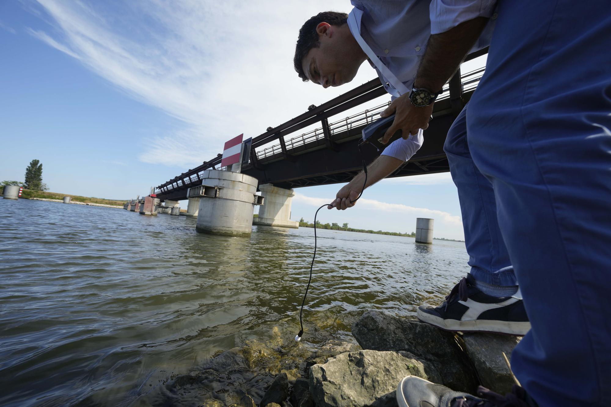 Rodolfo Laurenti, Deputy Director of the Remediation Consortium of the Po River, checks the salinity of the river, at a desalination barrier in Porto Tolle, Italy, on the Delta river, Friday, July 29, 2022. The amount of water entering the delta from the Po River is at an all-time low. (AP Photo/Luca Bruno)