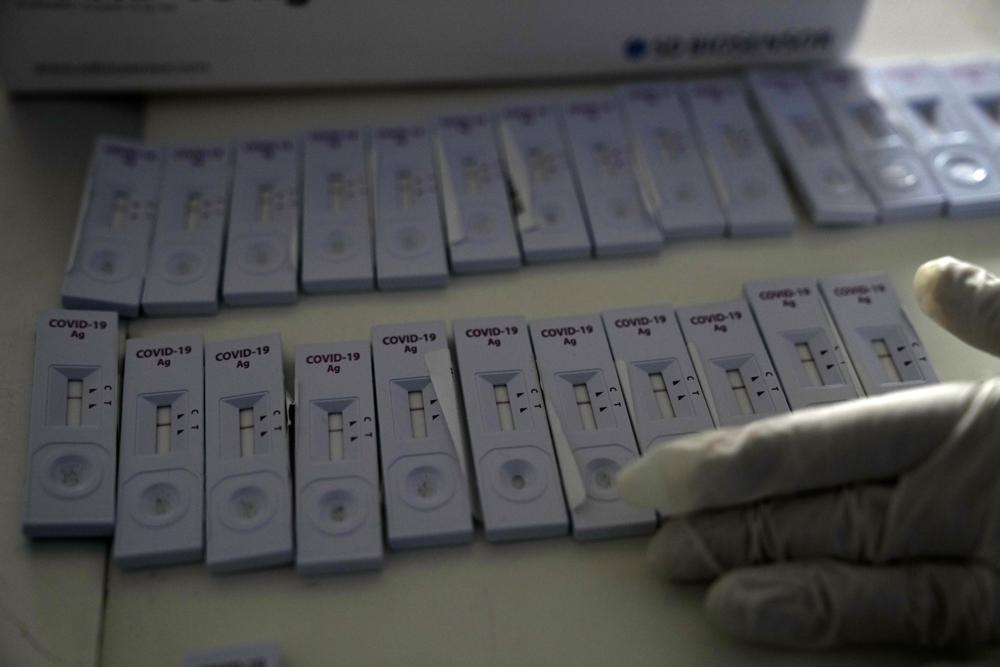 FILE - A member of the medical staff at the National Public Health Organisation (EODY) adjusts COVID-19 rapid tests in Athens, Greece, Monday, Nov. 15, 2021. The coronavirus's omicron variant kept a jittery world off-kilter Wednesday Dec. 1, 2021, as reports of infections linked to the mutant strain cropped up in more parts of the globe, and one official said that the wait for more information on its dangers felt like “an eternity.” (AP Photo/Thanassis Stavrakis, File)