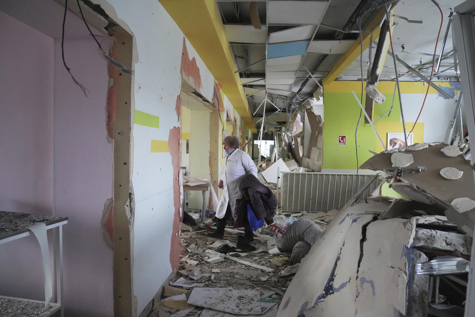 A medical worker walks through the hall of a maternity hospital damaged in a shelling attack in Mariupol, Ukraine, Wednesday, March 9, 2022. Associated Press journalists, who have been reporting from inside blockaded Mariupol since early in the war, documented this attack on the hospital and saw the victims and damage firsthand. They shot video and photos of several bloodstained, pregnant mothers fleeing the blown-out maternity ward, medics shouting, children crying. (AP Photo/Evgeniy Maloletka)