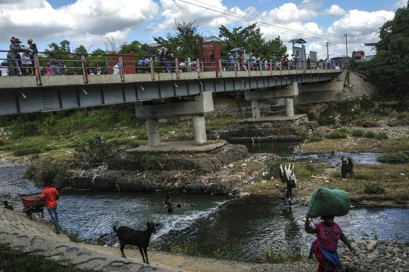 ARCHIVO - Gente se baña en el río Massacre en la frontera entre República Dominicana y Haití en Ouanaminthe, Haití 19 de noviembre de 2021. Las autoridades dominicanas han expulsado a 1.800 niños haitianos de regreso a su país, dijo UNICEF el 22 de noviembre de 2022. (AP Foto/Matias Delacroix, File)