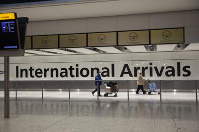 Dos personas transitan por una sala desierta en el aerouerto Heathrow de Londres el 26 de enero del 2021, durante el tercer confinamiento nacional de Inglaterra. Los países procuran ahora desarrollar pasaportes digitales que corroboran el que una persona se vacunó contra el COVID-19 y que se espera faciliten los viajes en avión. (AP Photo/Matt Dunham, File)