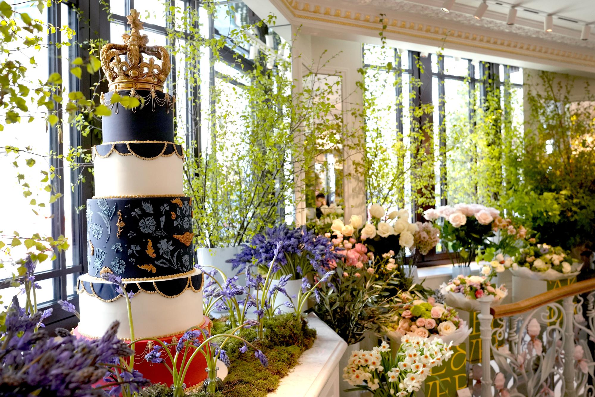 A display showing a Coronation themed cake and floral arrangements at the Dorchester Hotel in London, Thursday, April 20, 2023. The Dorchester Hotel, long a favorite with royals and celebrities, concocted a lavish, five-tier coronation cake and put up theater-style draping across its facade to re-create the decorations that it used to mark Queen Elizabeth II’s coronation in 1953 in preparation for King Charles III's coronation on May 6. (AP Photo/Kirsty Wigglesworth)