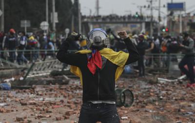 Manifestantes antigubernamentales chocan con la policía en Madrid, en las afueras de Bogotá, Colombia, el viernes 28 de mayo de 2021. Los colombianos han salido a las calles durante semanas en todo el país después de que el gobierno propusiera aumentos de impuestos a los servicios públicos, combustible, salarios y pensiones. (AP Foto/Ivan Valencia)