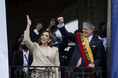 El nuevo presidente de Ecuador, Guillermo Lasso, derecha, y la primera dama María de Lourdes de Lasso saludan a la multitud el lunes 24 de mayo de 2021 desde el balcón del Palacio Carondelet, en Quito. (AP Foto/Carlos Noriega)