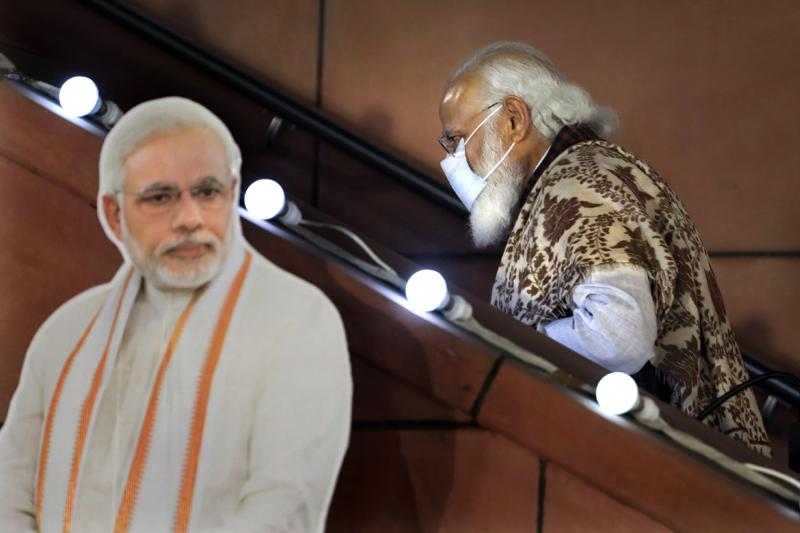 In this Nov. 11 2020, file photo, Indian Prime Minister Narendra Modi leaves after a function at the Bharatiya Janata Party headquarters following a state election in New Delhi, India. Twelve Indian government ministers resigned Wednesday, hours ahead of an expected reshuffle of Prime Minister Narendra Modi's Cabinet aimed at refurbishing its image after widespread criticism of its handling of the COVID-19 pandemic.