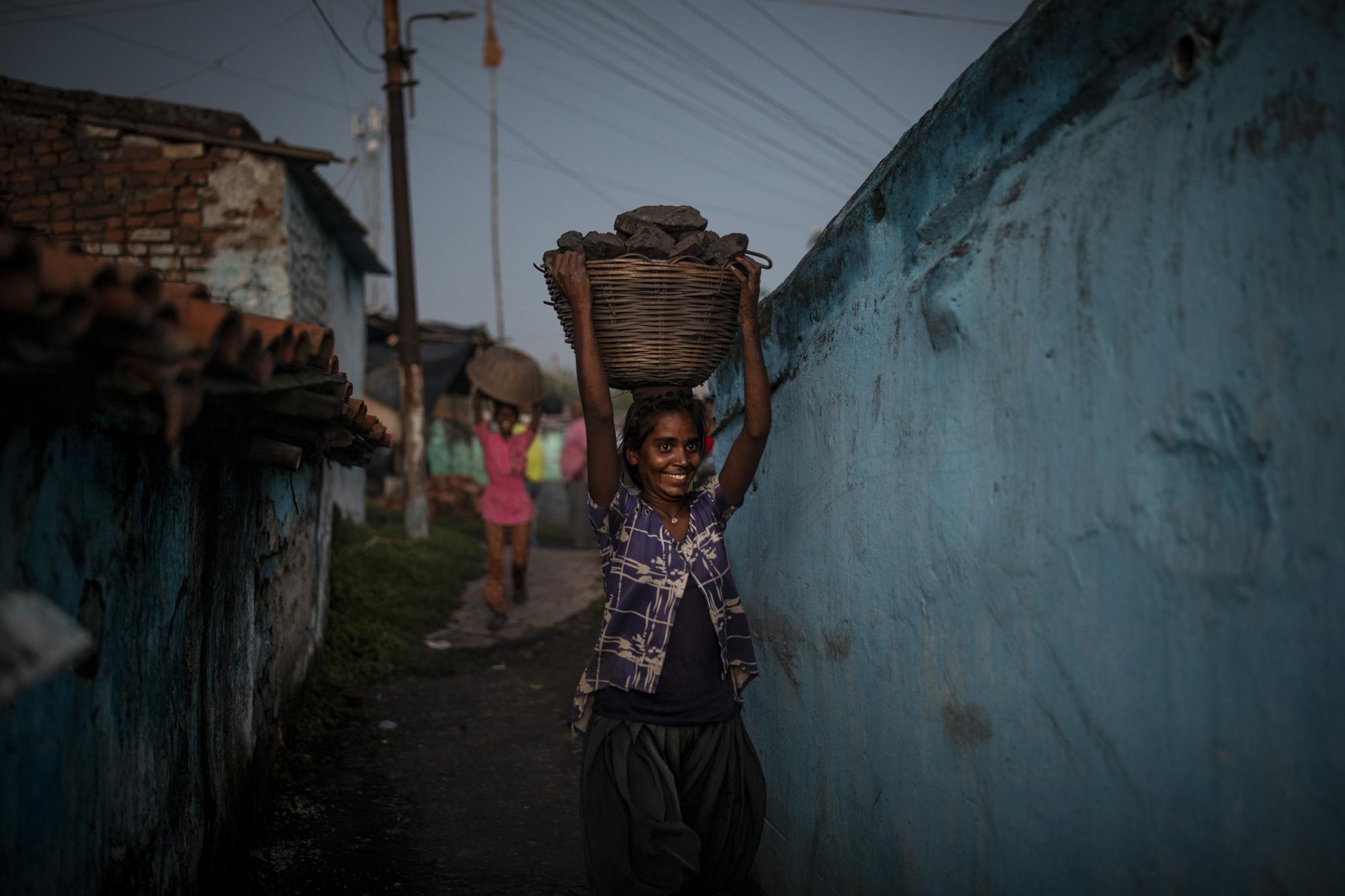 A young woman carries a basket of coal scavenged from a mine near Dhanbad, an eastern Indian city in Jharkhand state, Thursday, Sept. 23, 2021. A 2021 Indian government study found that Jharkhand state -- among the poorest in India and the state with the nation’s largest coal reserves -- is also the most vulnerable Indian state to climate change. Efforts to fight climate change are being held back in part because coal, the biggest single source of climate-changing gases, provides cheap electricity and supports millions of jobs. It's one of the dilemmas facing world leaders gathered in Glasgow, Scotland this week in an attempt to stave off the worst effects of climate change. (AP Photo/Altaf Qadri)