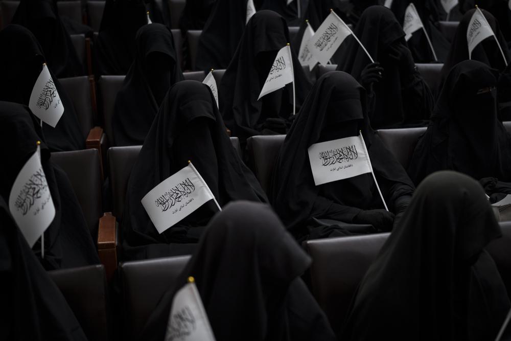 Women wave Taliban flags as they sit inside an auditorium at Kabul University's education center during a demonstration in support of the Taliban government in Kabul, Afghanistan, Saturday, Sept. 11, 2021. (AP Photo/Felipe Dana)