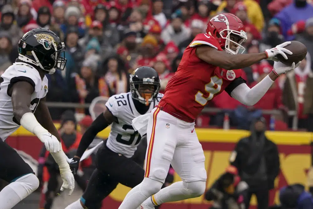 Kansas City Chiefs wide receiver JuJu Smith-Schuster (9) makes the catch against Jacksonville Jaguars cornerback Tyson Campbell (32) during the first half of an NFL divisional round playoff football game, Saturday, Jan. 21, 2023, in Kansas City, Mo. (AP Photo/Ed Zurga)