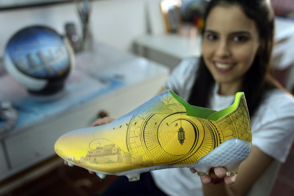 La artista plástica paraguaya Lili Cantero sostiene un zapato de fútbol que pintó a mano en San Lorenzo, Paraguay, el jueves 10 de noviembre de 2022. Ella decora botines, así como balones y lienzos, con detalles de los lujosos estadios del próximo torneo en Qatar, el primero que tendrá lugar en el Medio Oriente, y de los jugadores y equipos más buscados. Cantero prepara los últimos detalles de su muestra de arte inspirada en el fútbol denomiada, "8 Estadios, 8 Campeones, 1 Sueño: Qatar 2022". (Foto AP/Jorge Sáenz)