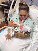 This July 27, 2021, photo provided by Melissa Syverson shows West Melbourne resident Kristen McMullen, 30, feeding her newborn daughter, Summer, at Holmes Regional Medical Center in Melbourne, Fla. Kristen only got to hold Summer for a few moments after giving birth via emergency C-section. The mother, who had COVID-19, was then taken to the ICU, where her condition worsened. She died on Aug. 6, 2021, 10 days after her little girl was born. (Melissa Syverson via AP)